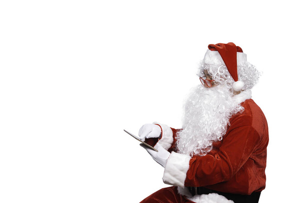 Portrait of santa clause play tablet on white background - Valokuva, kuva
