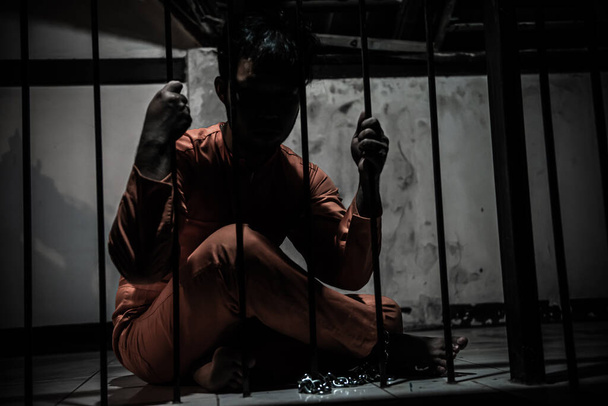 Asiat zoufalý v železné věznici, vězeňský koncept - Fotografie, Obrázek