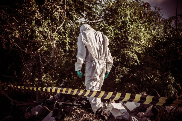 Aziatische wetenschapper dragen Chemische bescherming pak controleren gevaar chemische werken op gevaarlijke zone - Foto, afbeelding