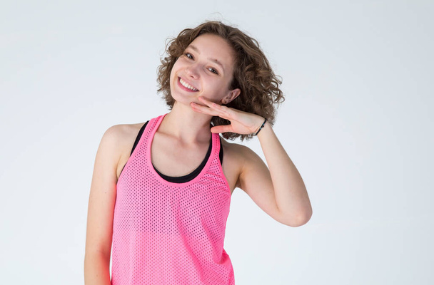 Portret pięknej młodej kobiety w różowej koszuli sportowej. Pielęgnacja skóry po treningu. - Zdjęcie, obraz