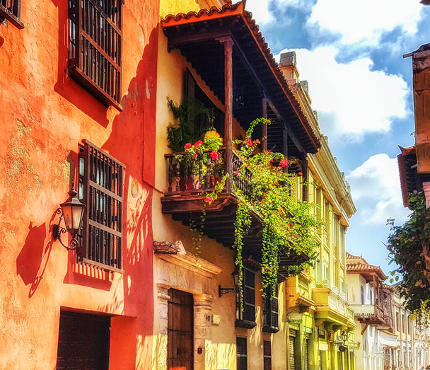 Kolombiya 'nın Cartagena de Indias şehrinin içinde, Plaza de los Coches' ta ahşap balkonları olan renkli İspanyol sömürge binaları. Unesco Dünya Mirası Bölgesi. - Fotoğraf, Görsel