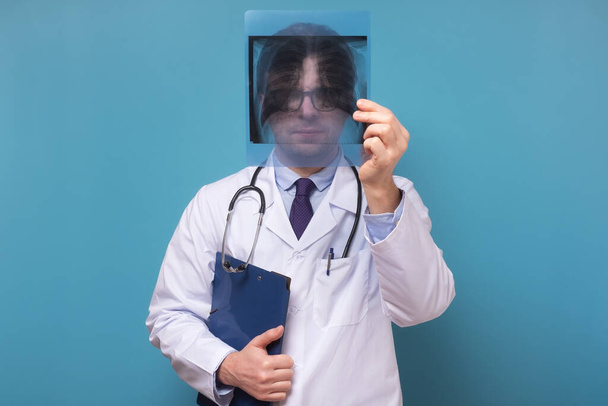 Мужчина врач, проверяющий рентгеновское изображение легких, фокусируется на рентгеновском снимке, подозревающем пневмонию.
 - Фото, изображение