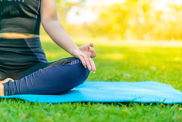 Asian woman doing yoga exercise and relax with sportswear in green park at summer - Fotoğraf, Görsel