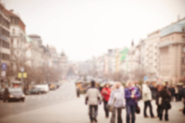 Defocused city street with old buildings and walking people in outerwear in cloudy day - Photo, Image