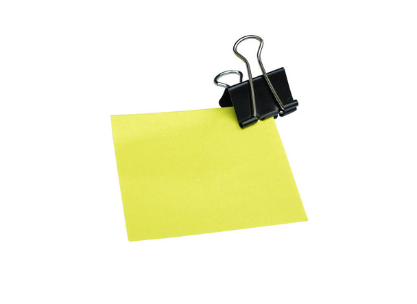 クローズアップコピースペースのある白い背景に分離された黄色のノートと黒のクリップ - 写真・画像