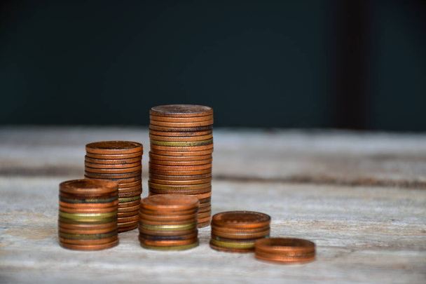 A moeda é ajustada em uma pilha na madeira e no fundo borrado. conteúdo sobre finanças. Copiar espaço fundo
 - Foto, Imagem