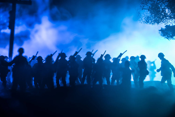 Концепция войны. Военные силуэты боевой сцены на фоне тумана на фоне неба войны, силуэт солдат мировой войны под облачным горизонтом ночью. Битва в разрушенном городе. Селективный фокус - Фото, изображение
