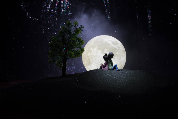 Silhouettes d'un couple au fond étoilé et lunaire. Joyeux couple la nuit sous le clair de lune. Décoration de table artistique créative
. - Photo, image