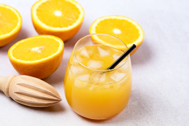 Tasty and Refreshing Orange Juice in Glass with Black Straws on Light Gray Background Fresh Ripe Oranges - Fotó, kép