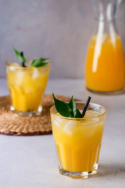 Tasty and Refreshing Orange Juice in Glass with Black Straws on Light Gray Background Fresh Ripe Oranges - Foto, afbeelding
