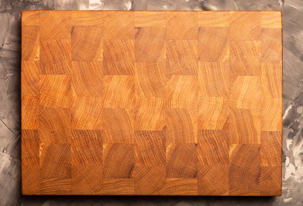 Composition with a cutting board on a textured plastered surface. - Φωτογραφία, εικόνα