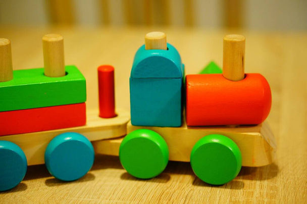 A closeup shot of a toy train with colorful blocks on a wooden surface - Φωτογραφία, εικόνα