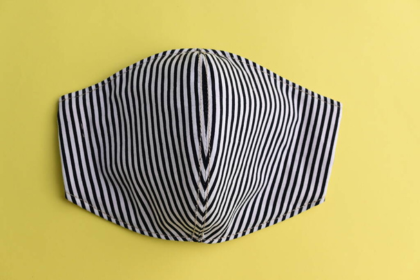 black fashion face mask handmade from fabric cloth on yellow background - Photo, Image