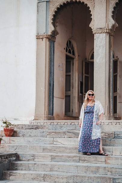 Beautiful blonde woman stands on the steps of the Monsoon Palace in Udaipur India - Fotoğraf, Görsel