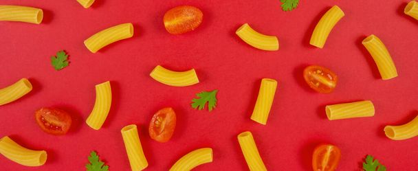 Macaroni, tomaten en peterselie patroon op rode achtergrond. Italiaans eten. Pasta samenstelling. Platte lay-out. - Foto, afbeelding