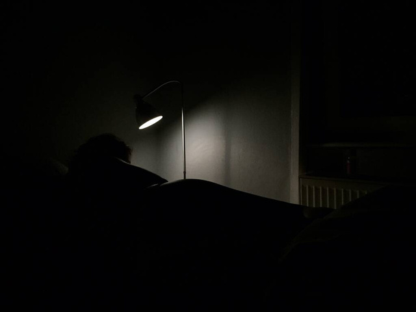A lamp illuminating the dark room it's placed in - Fotografie, Obrázek
