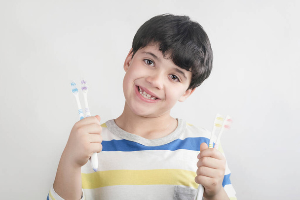 Enfant souriant avec brosse à dents en fond blanc
 - Photo, image