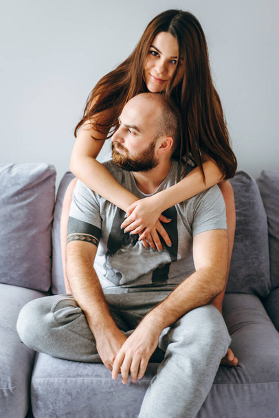 Pregnancy. Young couple waiting for baby. Wonderful expectant parents cuddle in their apartment awaiting birth - Фото, зображення