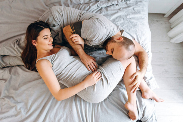 Pregnancy. Young couple waiting for baby. Pregnant woman and man in bed - Photo, Image