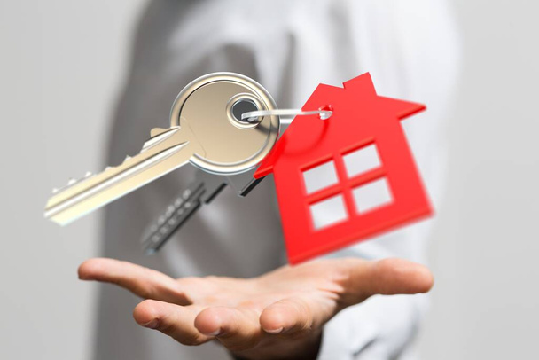 Un homme tenant une maison rouge et de grandes clés icône concept de propriété
 - Photo, image