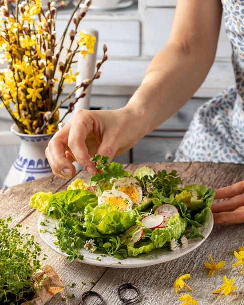Servir une salade de printemps avec des microverts et des plantes comestibles sauvages - des fleurs de potamot et de marguerite
 - Photo, image
