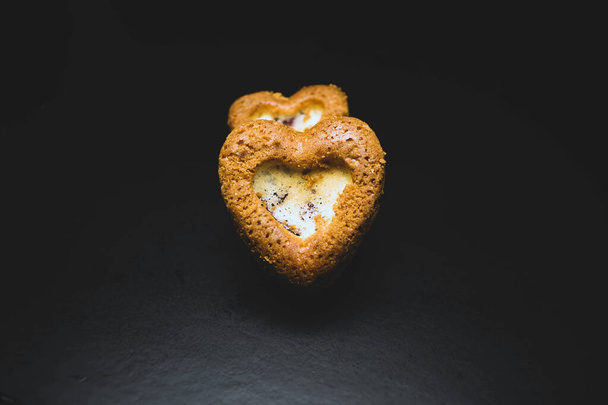 Heart shaped sponge cake. Bakery products. Black background. - Фото, изображение