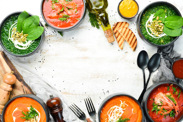 Ensemble de soupes savoureuses colorées sur fond blanc en bois. Soupe aux épinards, tomates et carottes. Aliments sains
. - Photo, image