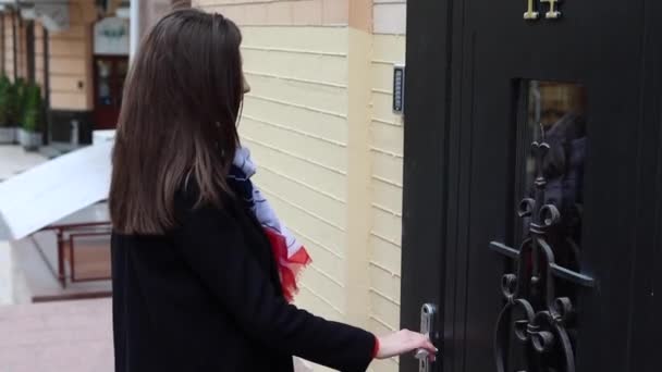 A fiatal nő kinyitja a háza ajtaját.. - Felvétel, videó