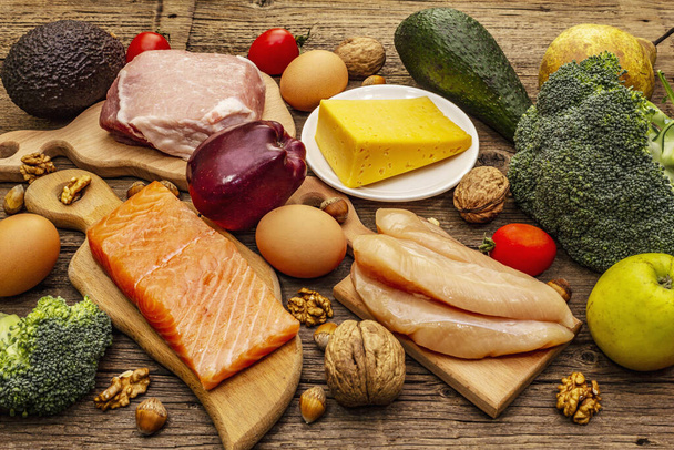 Set de productos dietéticos cetogénicos de moda. Paleo, pegan nutrición baja en carbohidratos. Carne, pescado, queso, frutas y verduras. Tableros de madera fondo
 - Foto, Imagen