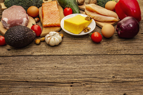 Набор модных кетогенных диетических продуктов. Палео, пиган с низким содержанием углеводов Мясо, рыба, сыр, фрукты и овощи. Деревянные доски
 - Фото, изображение