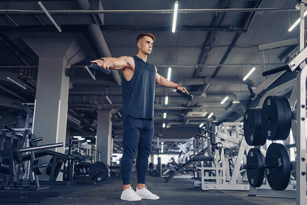 Young Man Preforming Dumbbell Lateral Raise - Exercise For Shoulders - Foto, afbeelding