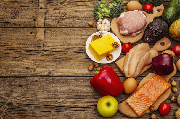 Set de productos dietéticos cetogénicos de moda. Paleo, pegan nutrición baja en carbohidratos. Carne, pescado, queso, frutas y verduras. Tableros de madera de fondo, vista superior
 - Foto, Imagen