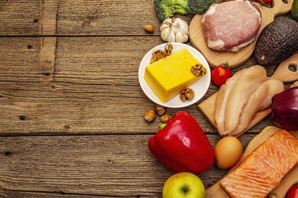 Set di prodotti dietetici chetogeni alla moda. Paleo, pegan basso contenuto di carboidrati nutrizione. Carne, pesce, formaggio, frutta e verdura. Tavole di legno sfondo, vista dall'alto
 - Foto, immagini