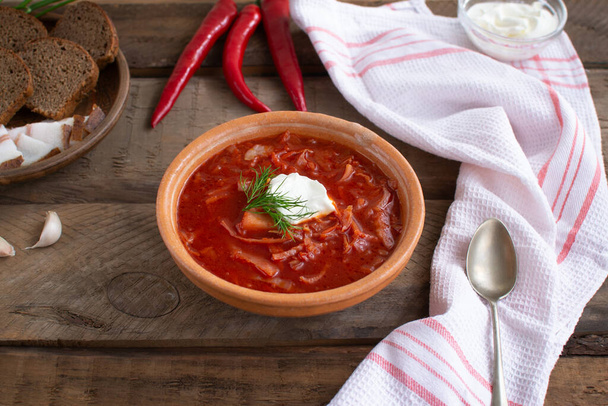 Κόκκινο μπορς. Ουκρανικό φαγητό. Ρουστίκ στυλ. Κόκκινη παντζάρι σούπα σερβίρεται με ξινή κρέμα και σκόρδο. - Φωτογραφία, εικόνα