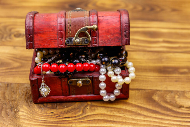 scrigno Vintage pieno di gioielli e accessori su sfondo di legno
 - Foto, immagini