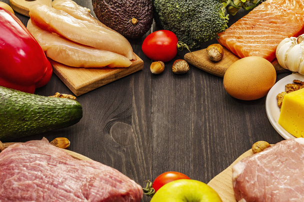 Set di prodotti dietetici chetogeni alla moda. Paleo, pegan basso contenuto di carboidrati nutrizione. Carne, pesce, formaggio, frutta e verdura. Tavole di legno nero sfondo
 - Foto, immagini