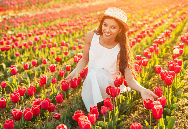 Delighted lady sitting in tulip field - Zdjęcie, obraz