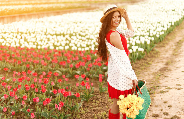 Cheerful woman standing near tulip field - Fotoğraf, Görsel