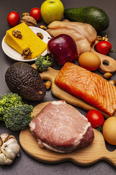 Перероблені продукти кетогенної дієти. Палео, низьковуглецеве живлення. М'ясо, рибу, сир, фрукти та овочі. Чорний камінь бетон - Фото, зображення