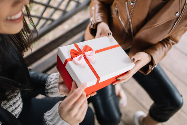 Top view of a female hands holding a gift box - 写真・画像