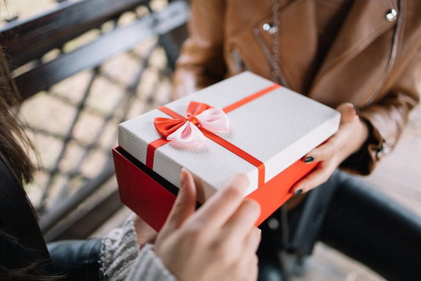 Womans hands opening a gift box with bow - 写真・画像