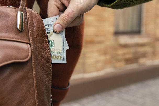kradzież kieszeni ukraść pieniądze z torebki kobieta męska ręka wziąć gotówkę dolarów powierzchni ulicy - Zdjęcie, obraz