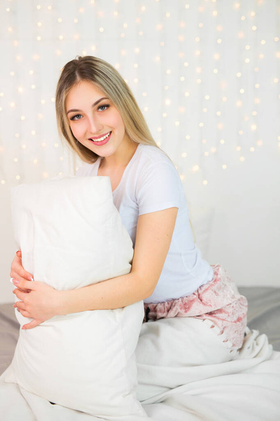 beautiful young woman in bed with a pillow - Фото, изображение