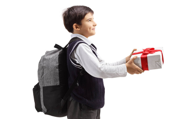 Schoolboy giving a present isolated on white background - Φωτογραφία, εικόνα