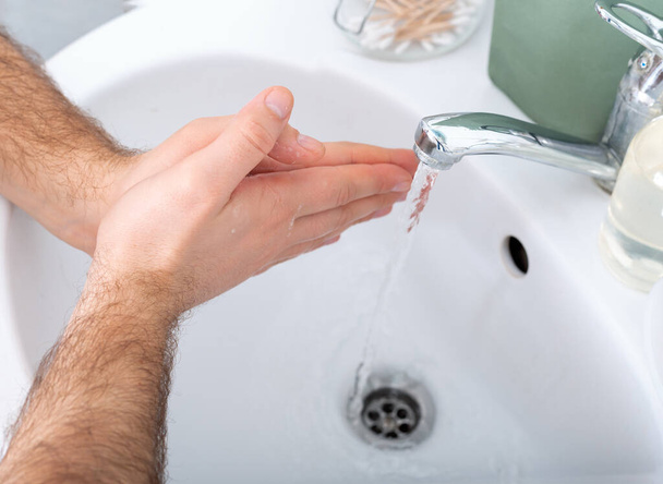 抗菌石鹸と水で手を洗う男.衛生概念。コロナウイルス対策ハンド衛生防腐剤。健康のための皮膚消毒. - 写真・画像