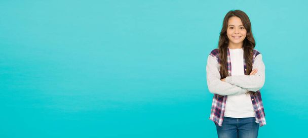 Studio shot of glad child. childhood happiness. Pleasant emotions. stylish teen girl turquoise background. pretty teen girl with long hair. kid fashion advertising. Back to school. copy space - Photo, image
