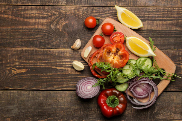 Gemüsescheiben für Salate oder andere Gerichte auf einem braunen Holztisch. Ansicht von oben. Platz für Text. Zutaten zum Kochen. - Foto, Bild