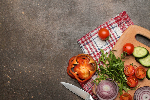 Szeletelt zöldségek és fűszerek készlete saláták vagy más ételek sötét asztalon történő elkészítéséhez. Kiváló kilátás. a szöveg helye - Fotó, kép