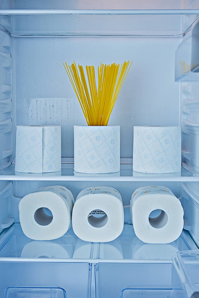 Rolos de papel higiênico e espaguete em prateleiras no frigorífico como símbolo de histeria e sobre-compra entre pessoas em quarentena coronavírus Covid-19 - Foto, Imagem