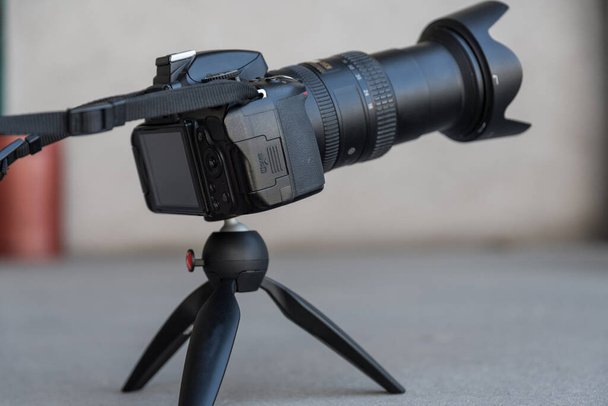 Digital camera stands in studio on rotating mini tripod - camera copy space - Photo, Image